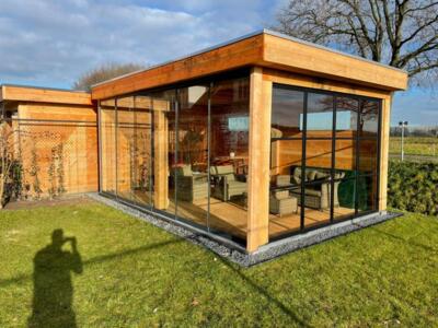 L&auml;ndliches Douglasien-Gartenzimmer mit gro&szlig;en Glasw&auml;nden im freien Feld