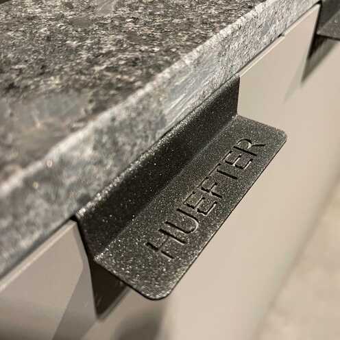 Detailaufnahme einer modernen schwarzen Küchenfront mit dezentem Griff für ein klares Design