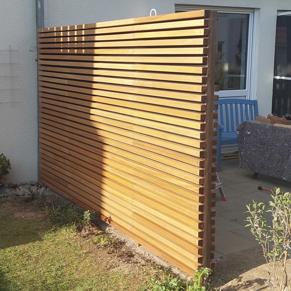 Ipe Lamellenschutting aus quadratischen Latten Ipe Lamellenzaun gefertigt aus robusten Holzleisten für eine moderne Gartengestaltung