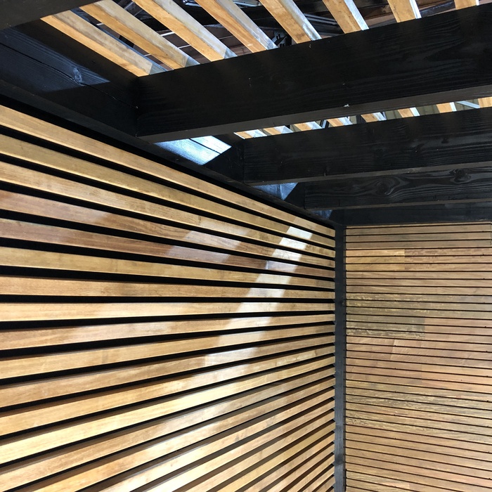 Moderne Wand aus Ipe-Holz in 4x4-Lamellen in der Überdachung