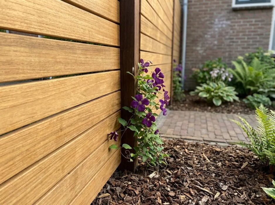 Detail der 7 cm Teak Lamellen an einem Azobé Pfosten mit Clematis