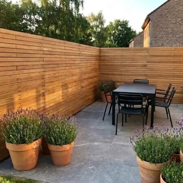 Rund um die Terrasse: Teak Sichtschutz mit 7 cm Lamellen über Eck an einer Terrasse mit Esstisch