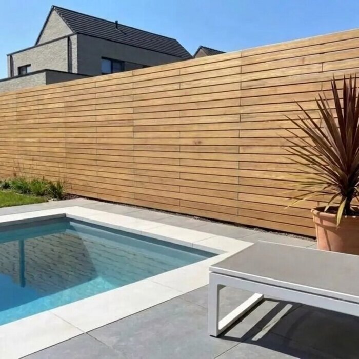 Am Pool: Teak Sichtschutzzaun mit 9 cm Lamellen an einem Pool im modernen Garten