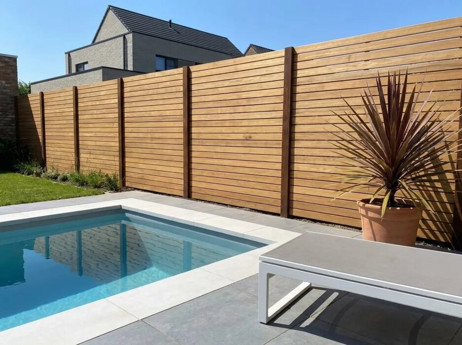 Teak Sichtschutzzaun mit 9 cm Lamellen an einem Pool im modernen Garten