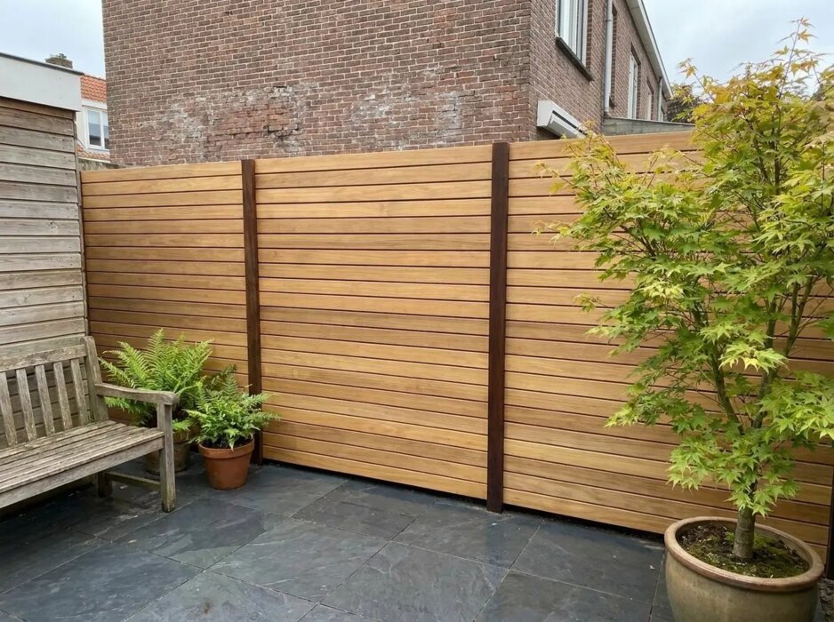 Teak Zaun mit 9 cm Lamellen in einem Stadtgarten mit Fächerahorn