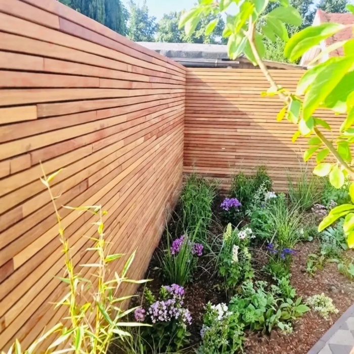 Teakholz Sichtschutzzaun mit 5 cm Lamellen in einer Gartenecke