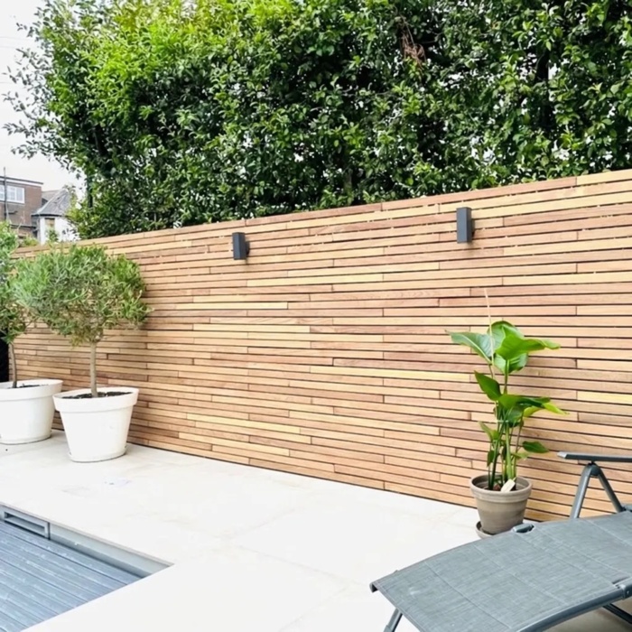 Teakholz Zaun mit waagerechten 5 cm Lamellen auf einer Terrasse