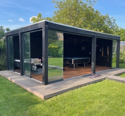 Modernes Gartenhaus mit Glastüren und Veranda