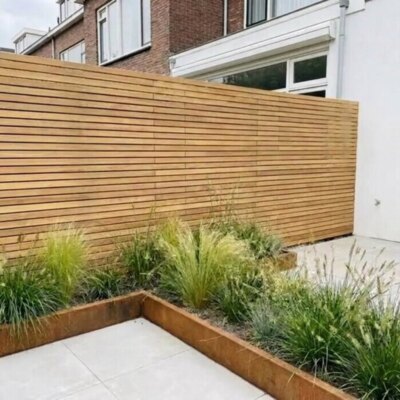 Teak Zaun mit 5 cm Lamellen im Reihenhausgarten mit Pflanzbeet aus Cortenstahl