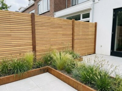 Teak Zaun mit 5 cm Lamellen im Reihenhausgarten mit Pflanzbeet aus Cortenstahl