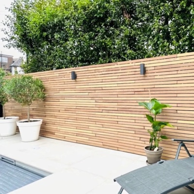 Teakholz Zaun mit waagerechten 5 cm Lamellen auf einer Terrasse