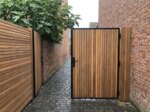 Ipe Tor nach Maß zwischen Backsteinmauern in einem Stadtgarten