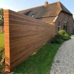 Ipe Zaun mit 9 cm Lamellen in einem Landhausgarten