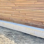 Ipé Lamellenzaun mit schwarzer EPDM-Folie für 100% Sichtschutz und modernen Kontrast.