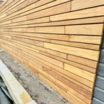 Detailansicht der unsichtbaren Befestigung von Ipé Lamellen mit schwarzen Cobra-Clips.