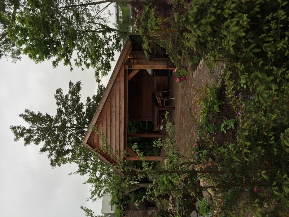 Klassische Douglasie Remise mit asymmetrischem Dach im ländlichen Garten
