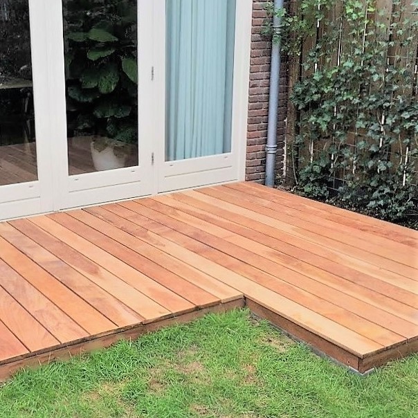 Luxuriöses Hartholzdeck mit nahtlosem Anschluss an die Flügeltüren zum Garten